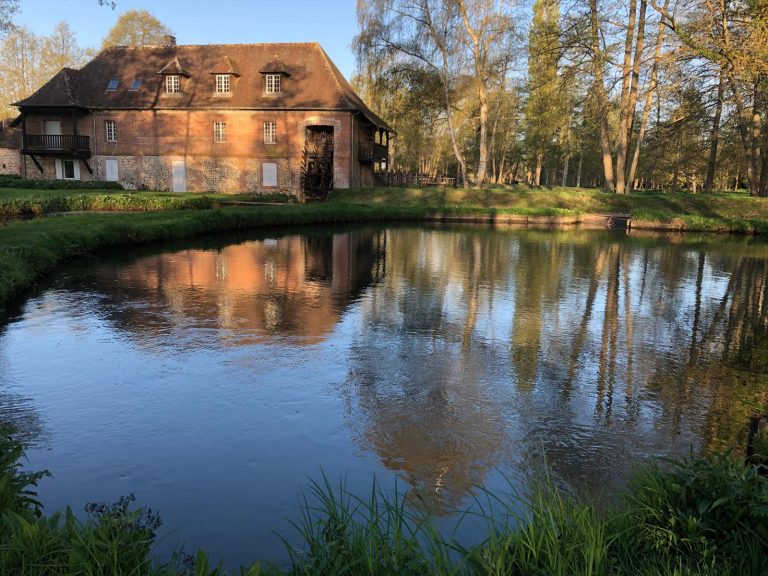 Le bâtiment du moulin vu depuis l'autre rive de l'étang