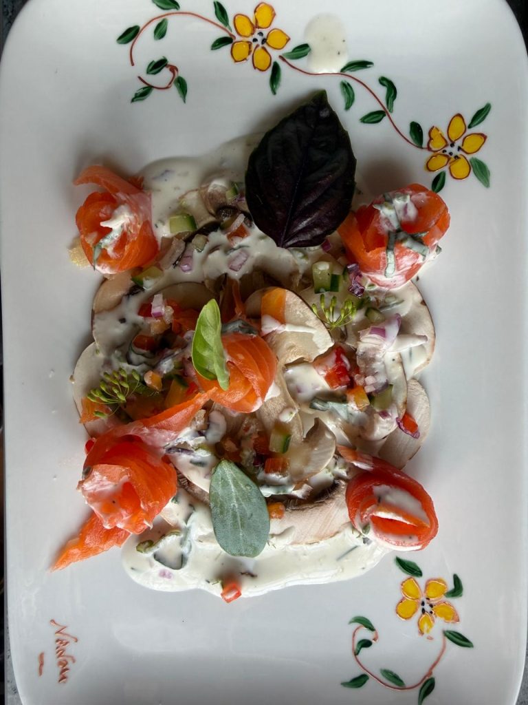 Carpaccio de champignons de Paris, roses de saumon fumé et crème aux herbes fraîches