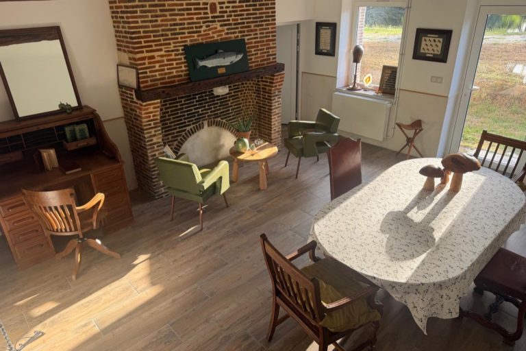 Salon-salle à manger du moulin : cheminée en brique et grande table dressée
