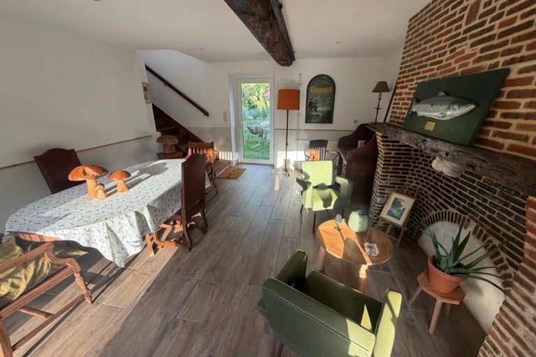 Salle à manger du moulin, table dressée et porte-fenêtre sur le jardin