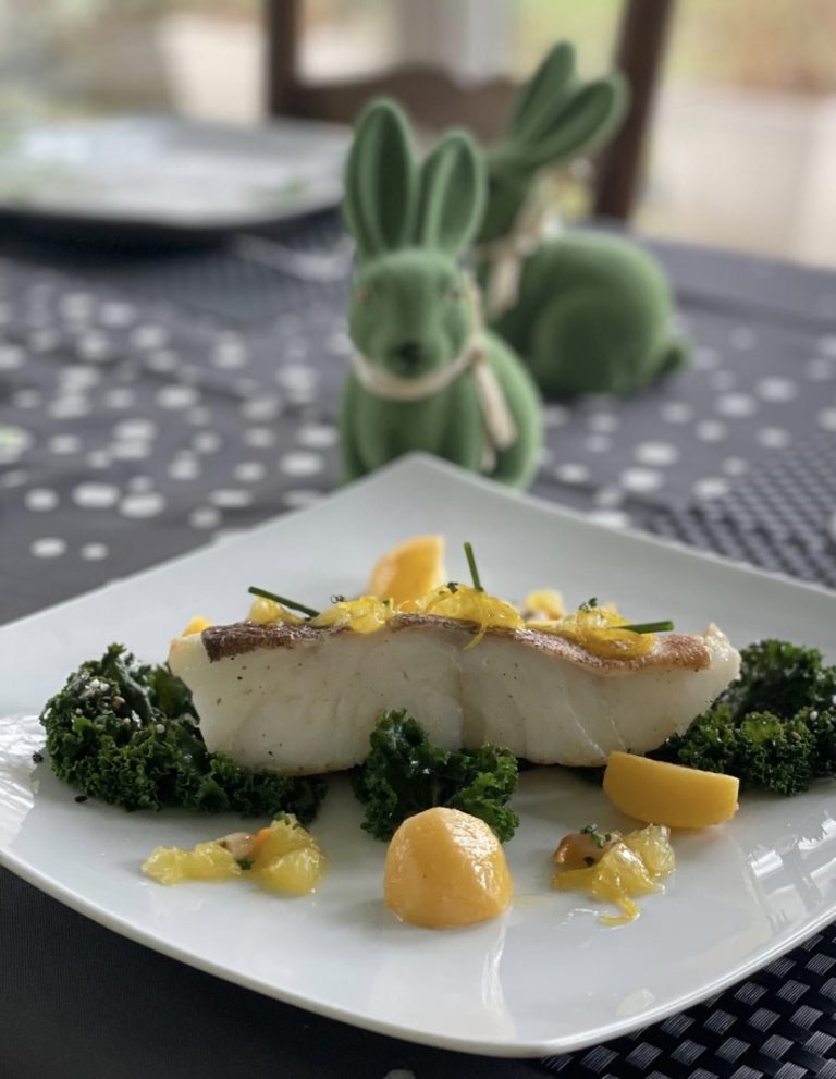 Le même dos de poisson poêlé au chou kale et aux agrumes, dressé sur une table de Pâques décorée de lapins en céramique verte