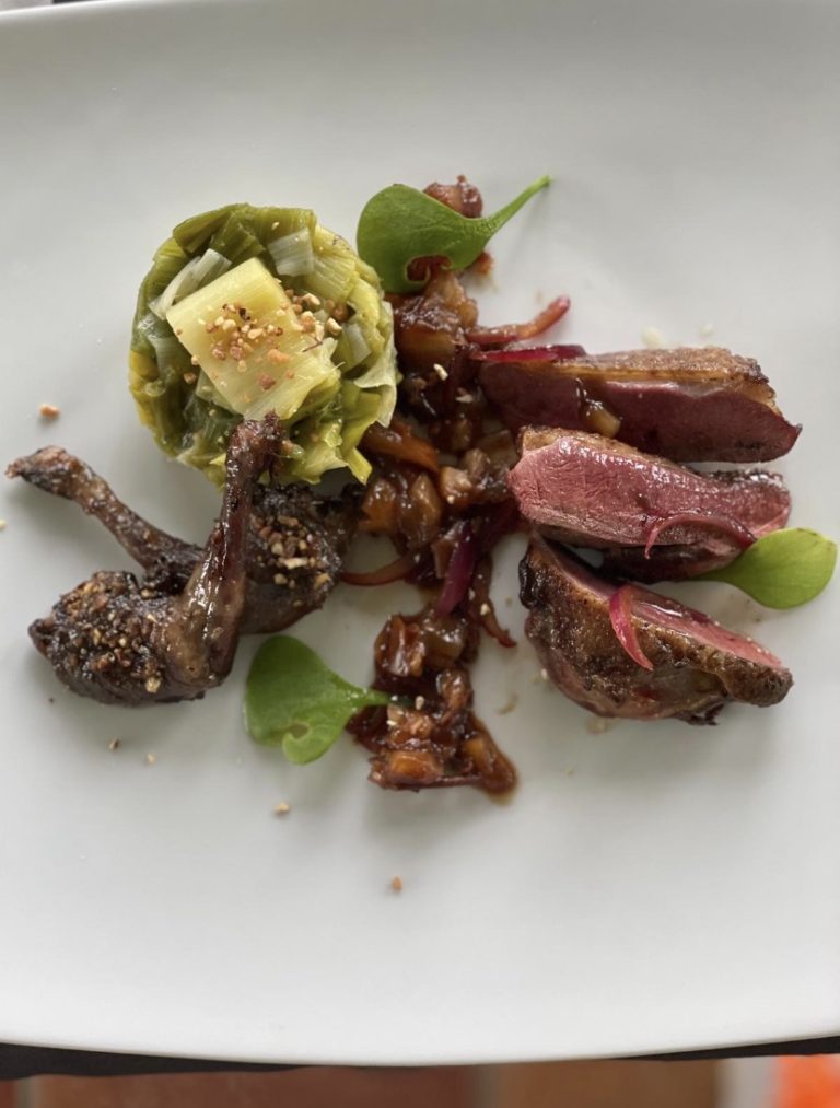 Magret de canard tranché et cuisse confite, poireaux fondants et compotée d’oignons rouges, pousses de pourpier
